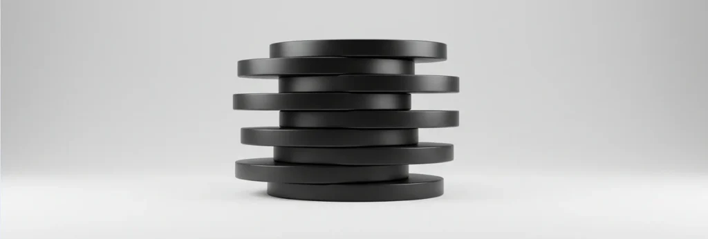 A stack of eight black, round disks arranged slightly askew against a plain gray background.